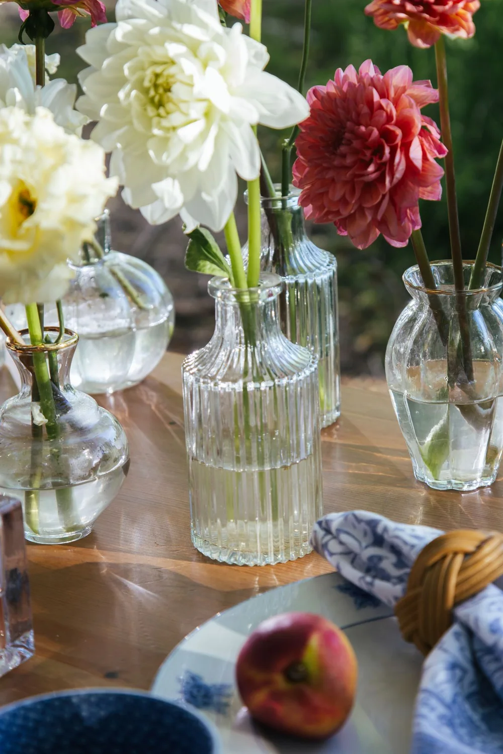 Referência ilustrativa de flores claras e folhagens em uma mesa posta